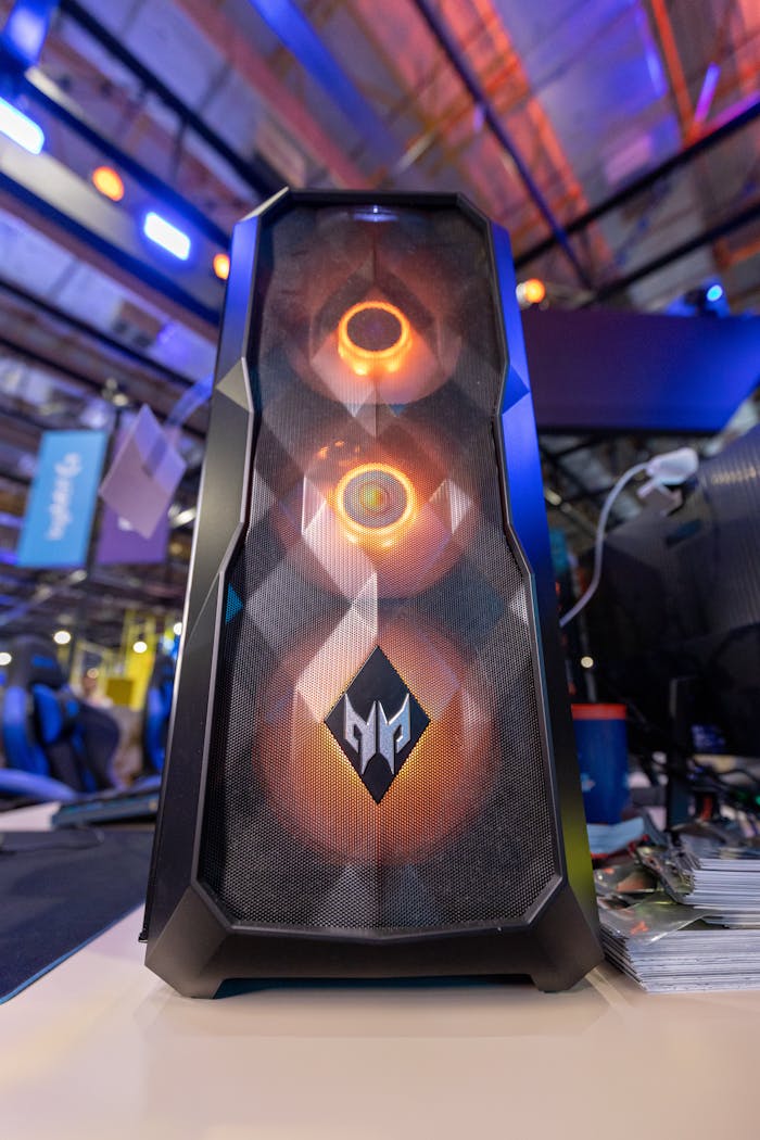 Close-up of a gaming PC with RGB lighting on display at a tech expo. Ideal for tech enthusiasts.